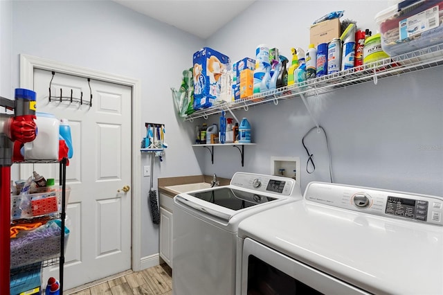 23510 Oak Prairie Cir, Sorrento, FL 32776 - clothes washing area with washer and clothes dryer, light wood-type flooring, and cabinet space