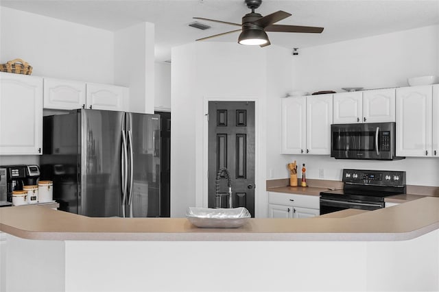 23510 Oak Prairie Cir, Sorrento, FL 32776 - kitchen with stainless steel microwave, black range with electric stovetop, freestanding refrigerator, a ceiling fan, and white cabinetry