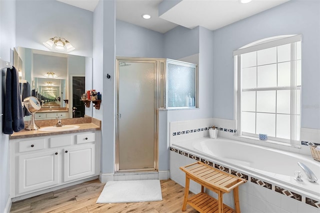 23510 Oak Prairie Cir, Sorrento, FL 32776 - bathroom with a shower stall, vanity, wood finished floors, and a bath