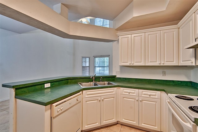 kitchen with a sink, white appliances, dark countertops, and white cabinetry