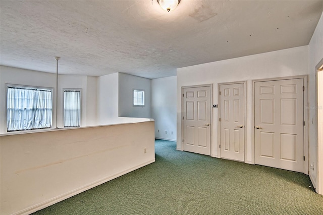 spare room featuring carpet floors and a textured ceiling