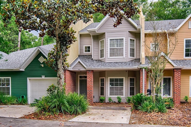 multi unit property with a garage, roof with shingles, concrete driveway, and a porch