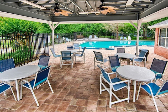 view of patio / terrace featuring ceiling fan, outdoor dining space, and a community pool
