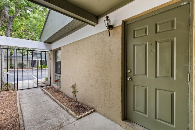 doorway to property featuring stucco siding