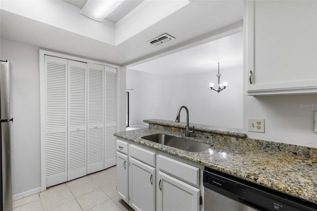 kitchen with a sink, dishwasher, light tile patterned floors, light stone countertops, and a chandelier