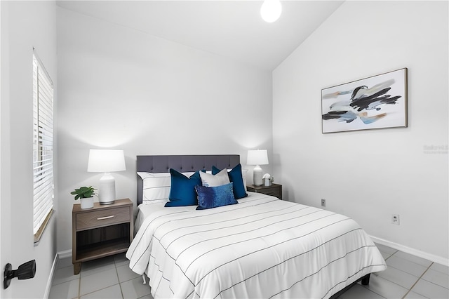 tiled bedroom featuring vaulted ceiling and baseboards