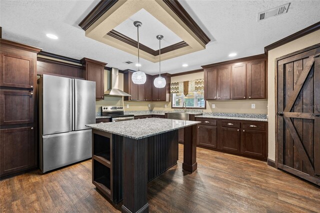 kitchen featuring appliances with stainless steel finishes, wall chimney exhaust hood, ornamental molding, dark wood-style flooring, and a kitchen island