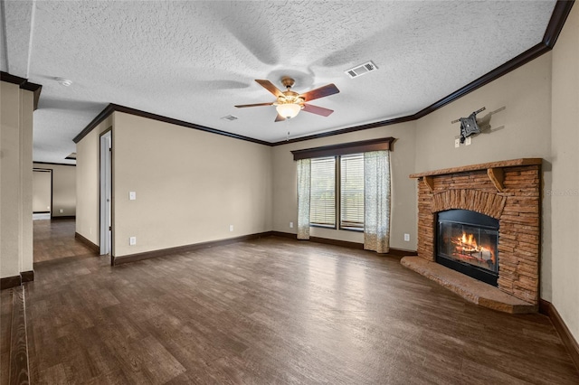 unfurnished living room with dark wood-type flooring, ornamental molding, a ceiling fan, a glass covered fireplace, and baseboards