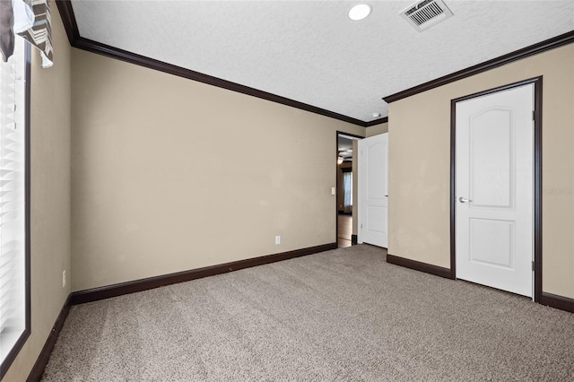 unfurnished bedroom featuring carpet, baseboards, crown molding, and a textured ceiling