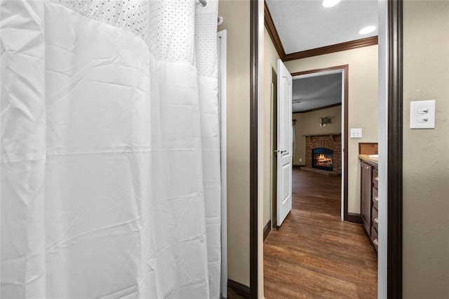 hallway with ornamental molding and dark wood-style floors