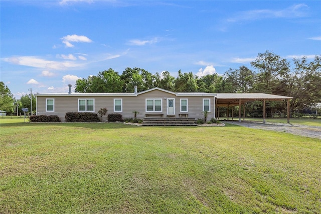 manufactured / mobile home with a carport, dirt driveway, and a front yard