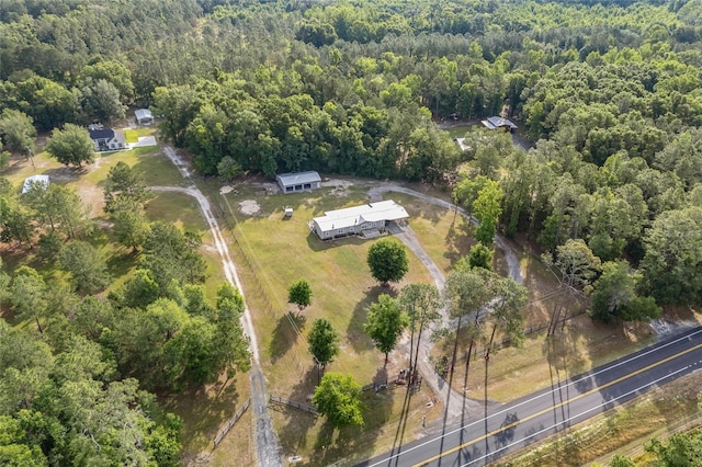 aerial view of property and surrounding area featuring a forest