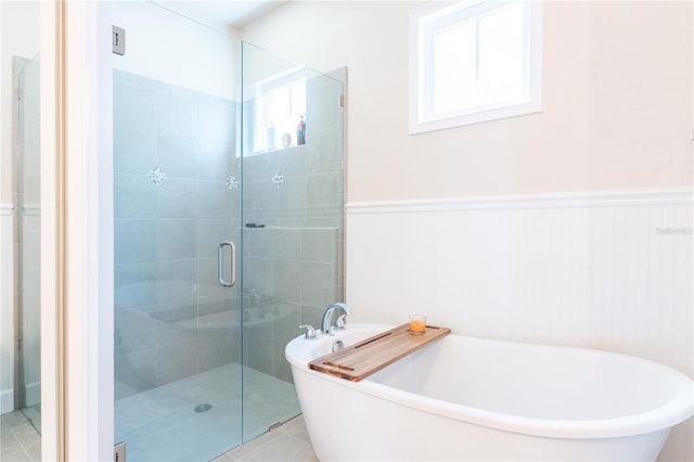 3242 NW 23rd Rd, Gainesville, FL 32605 - full bath featuring a shower stall, a wainscoted wall, a freestanding tub, and tile patterned floors