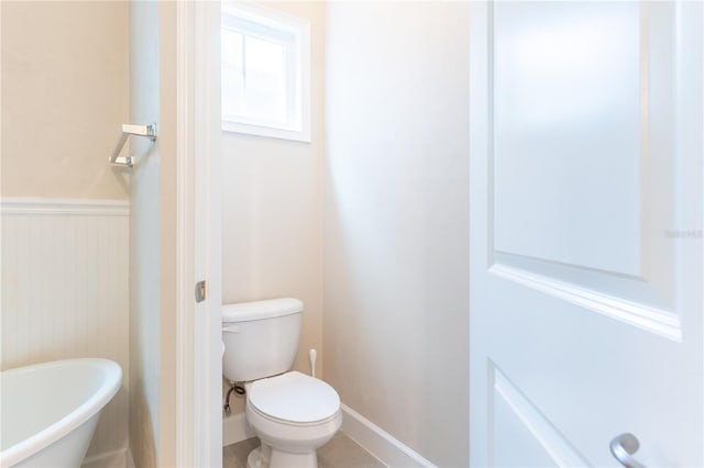 3242 NW 23rd Rd, Gainesville, FL 32605 - bathroom featuring toilet, a freestanding tub, and wainscoting