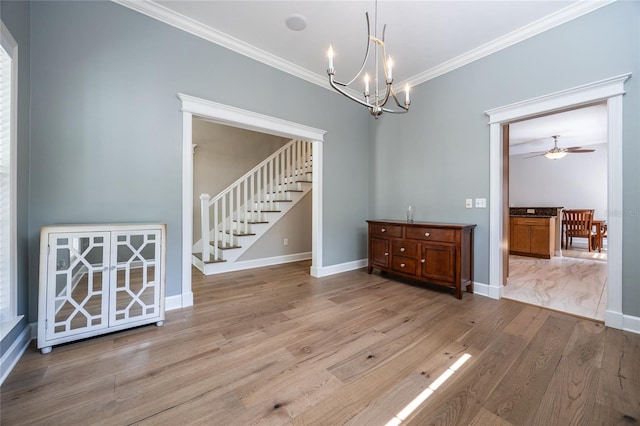 13209 SW 3rd Ln, Newberry, FL 32669 - spare room with stairway, ornamental molding, a chandelier, baseboards, and wood finished floors