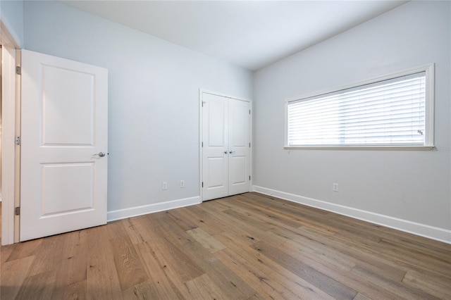13209 SW 3rd Ln, Newberry, FL 32669 - unfurnished bedroom featuring light wood-style floors, baseboards, and a closet