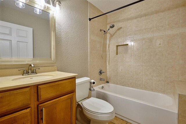 bathroom featuring a textured wall, toilet, vanity, and washtub / shower combination