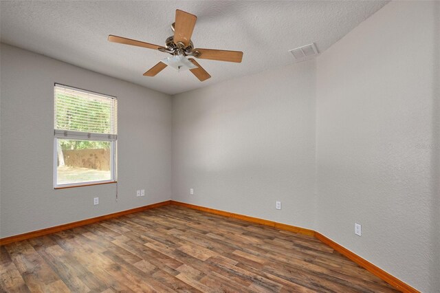 unfurnished room featuring wood finished floors, baseboards, a textured ceiling, and ceiling fan