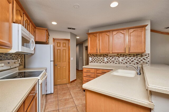 kitchen featuring white appliances, a sink, backsplash, light countertops, and light tile patterned floors