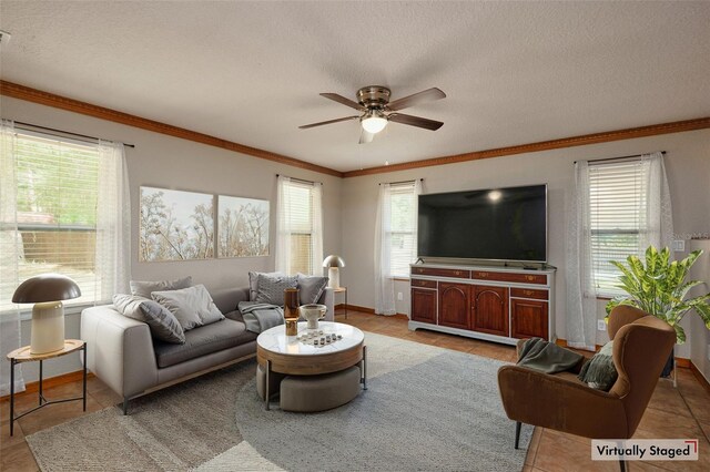 living area with a ceiling fan, baseboards, crown molding, a textured ceiling, and light tile patterned floors