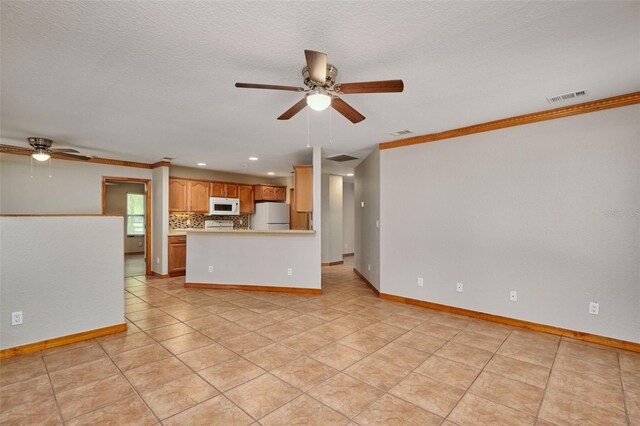 unfurnished living room with ceiling fan, ornamental molding, recessed lighting, baseboards, and light tile patterned floors