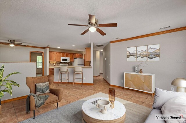 living room featuring a ceiling fan, light tile patterned floors, baseboards, crown molding, and recessed lighting