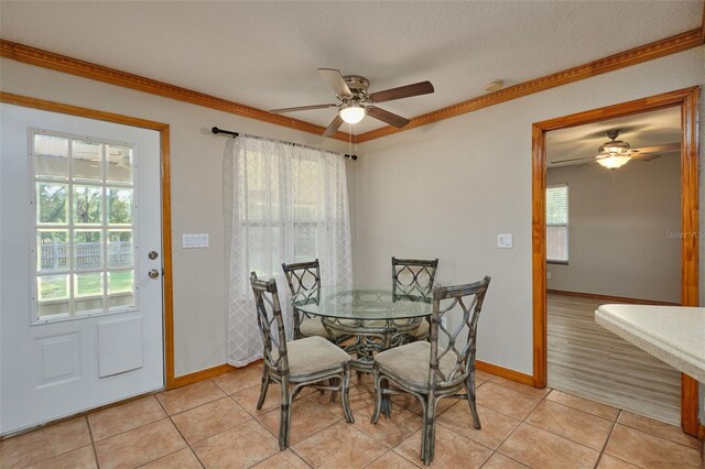 dining space featuring ceiling fan, plenty of natural light, crown molding, and light tile patterned floors