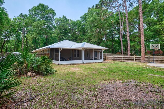 rear view of property featuring a sunroom and metal roof