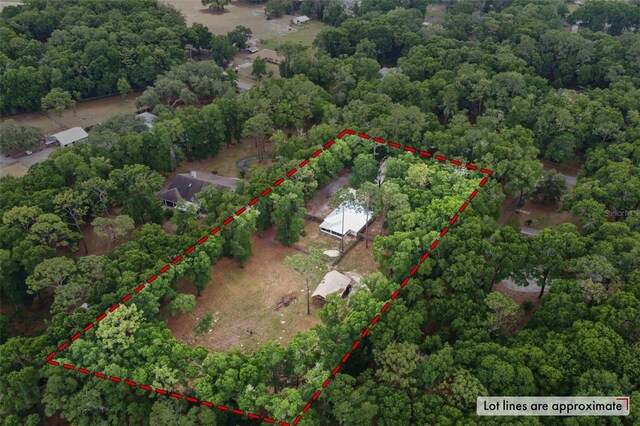 aerial view of property and surrounding area featuring property boundaries highlighted and a forest
