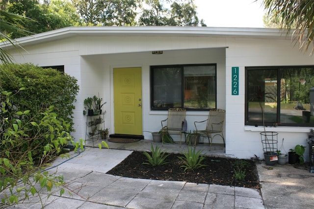 1226 NE 17th Ave, Gainesville, FL 32609 - view of exterior entry featuring a porch and concrete block siding