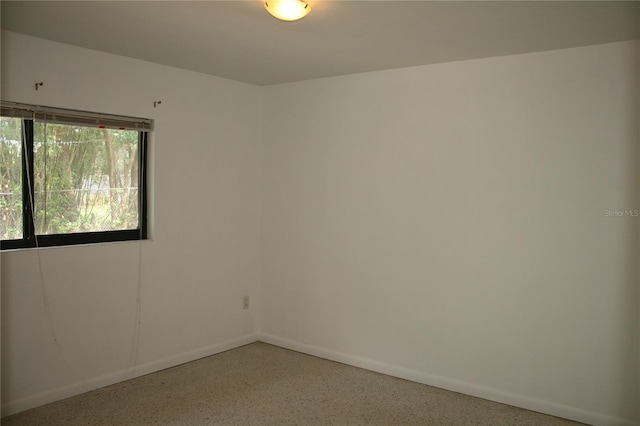 1226 NE 17th Ave, Gainesville, FL 32609 - unfurnished room with dark speckled floor and baseboards