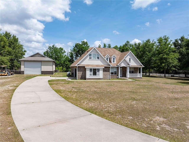 view of front of home with a detached garage, an outdoor structure, brick siding, covered porch, and concrete driveway