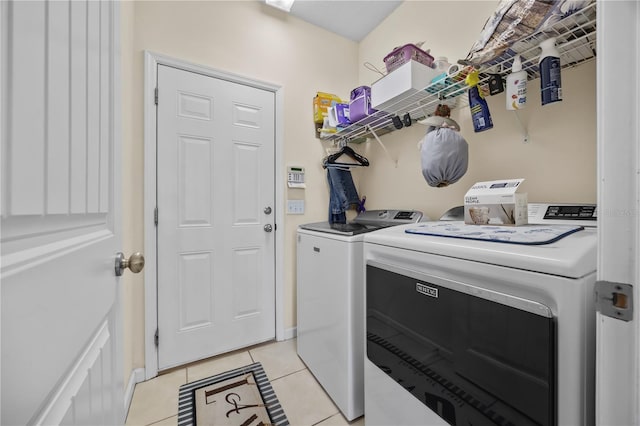 clothes washing area featuring washer and dryer and light tile patterned flooring