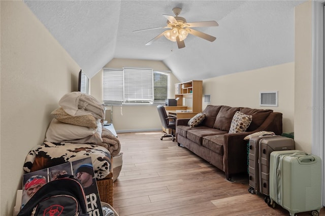 living room with light wood-type flooring, vaulted ceiling, an office area, ceiling fan, and baseboards