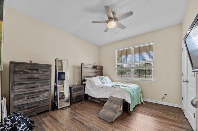 bedroom with wood finished floors, baseboards, a textured ceiling, and ceiling fan