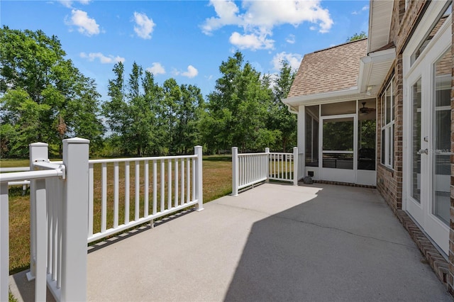 view of patio with a sunroom and view of scattered trees