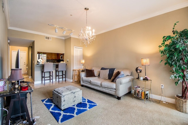 carpeted living room featuring ornamental molding, a chandelier, baseboards, and rail lighting