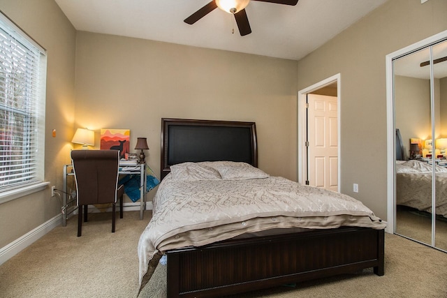 bedroom with light colored carpet, a closet, ceiling fan, and baseboards