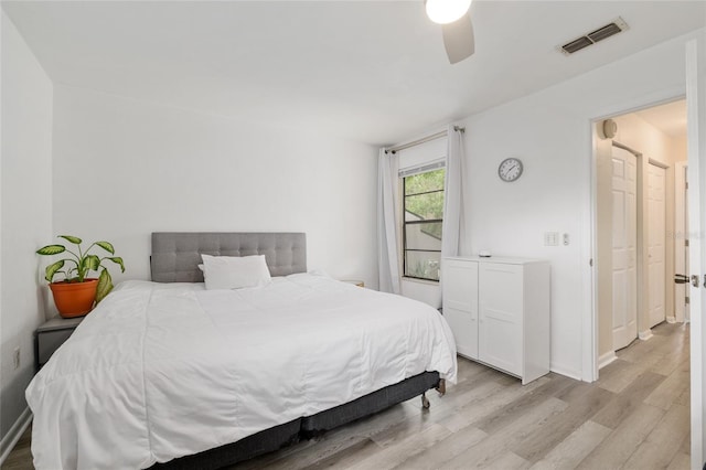 bedroom with light wood-type flooring, a ceiling fan, and baseboards