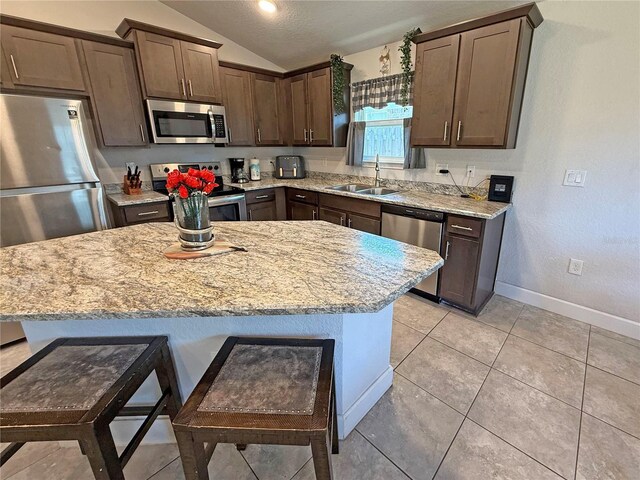 15835 NW 123rd Ave, Alachua, FL 32615 - kitchen with appliances with stainless steel finishes, lofted ceiling, a sink, baseboards, and a center island