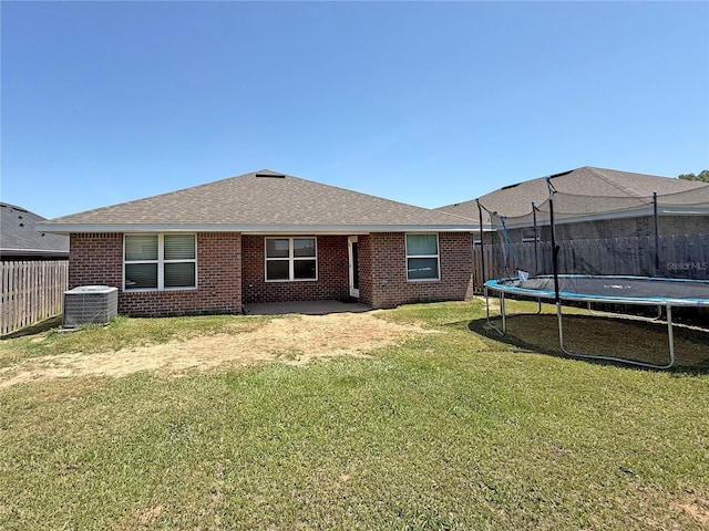 15835 NW 123rd Ave, Alachua, FL 32615 - back of house with a trampoline, central AC unit, brick siding, a shingled roof, and a patio