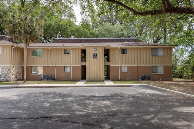 507 NW 39th Rd Unit 235, Gainesville, FL 32607 - view of front of house with uncovered parking, roof with shingles, board and batten siding, and brick siding