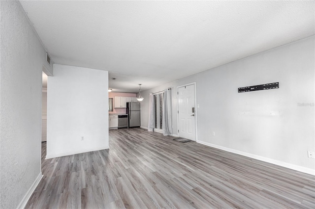 507 NW 39th Rd Unit 235, Gainesville, FL 32607 - unfurnished living room with wood finished floors and baseboards