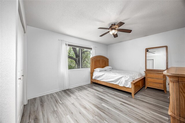507 NW 39th Rd Unit 235, Gainesville, FL 32607 - bedroom with wood finished floors, a textured ceiling, ceiling fan, and baseboards