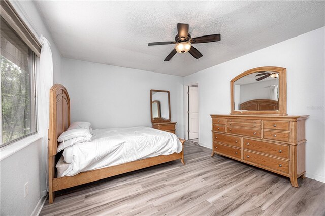 507 NW 39th Rd Unit 235, Gainesville, FL 32607 - bedroom featuring light wood finished floors, baseboards, ceiling fan, and a textured ceiling