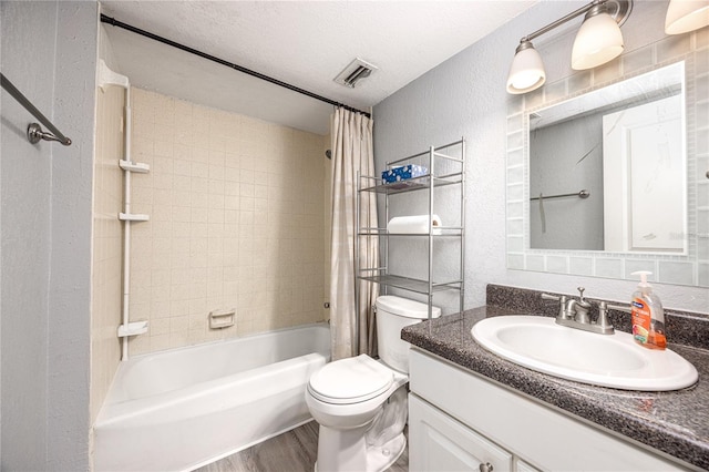 507 NW 39th Rd Unit 235, Gainesville, FL 32607 - full bath featuring a textured wall, toilet, wood finished floors, shower / bath combo with shower curtain, and vanity