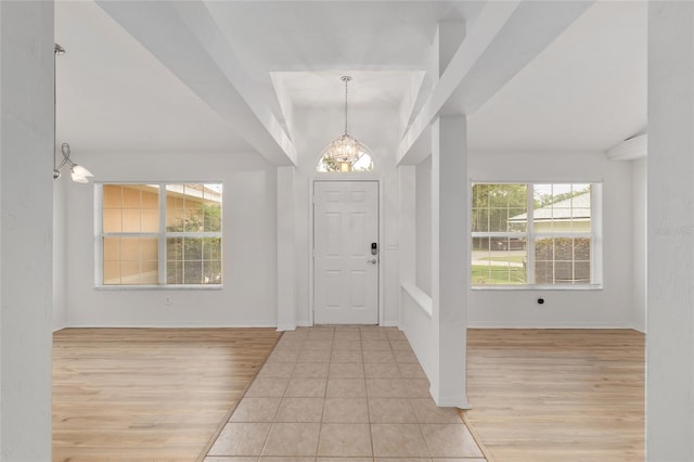 foyer featuring a chandelier, light wood-style flooring, and baseboards