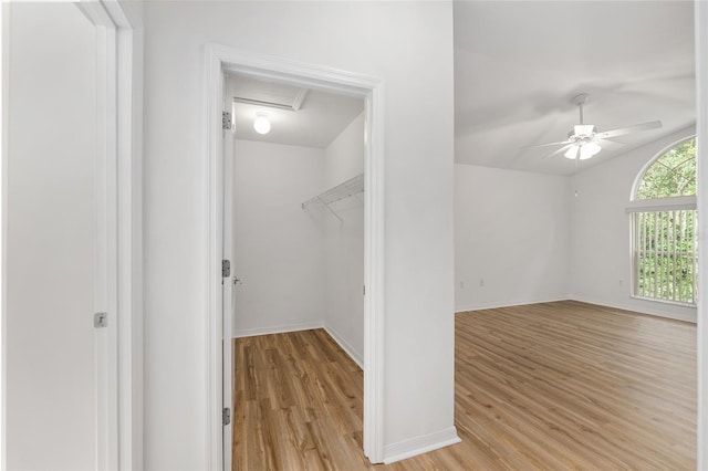 interior space with light wood-style flooring, ceiling fan, and attic access