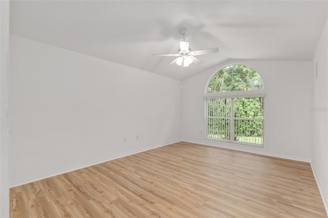 unfurnished room featuring vaulted ceiling, light wood finished floors, a ceiling fan, and baseboards