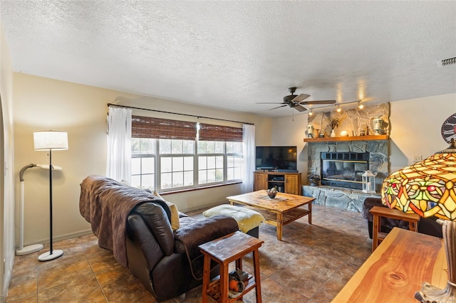 7450 SE State Road 121, Morriston, FL 32668 - living room with ceiling fan, a textured ceiling, and a stone fireplace